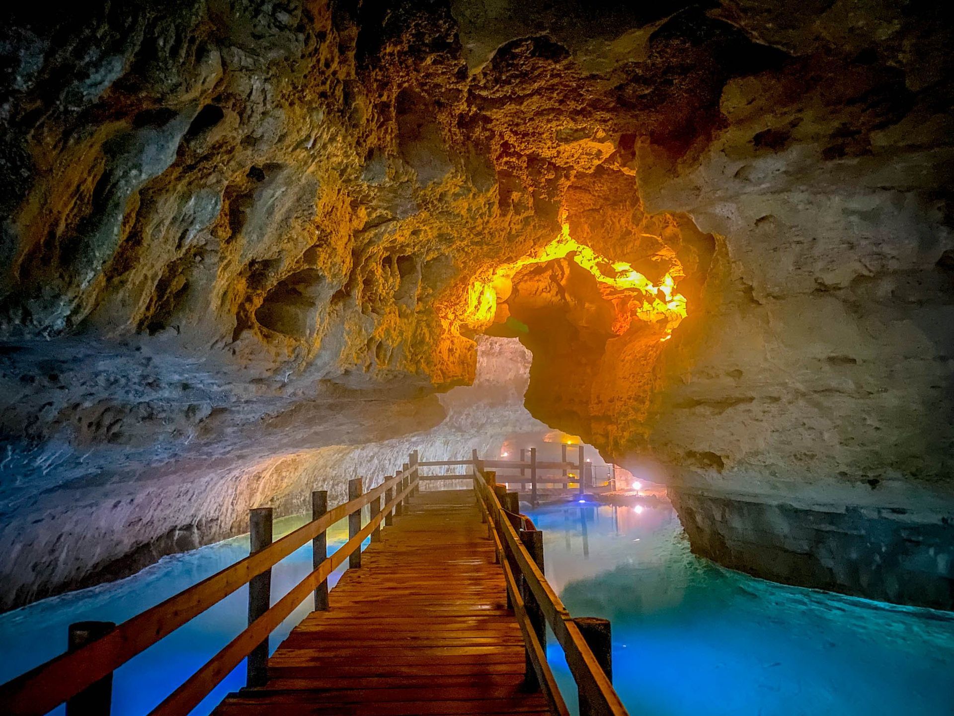 There is a wooden bridge in the middle of a cave.