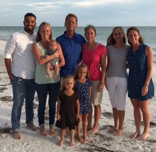 A group of people posing for a picture on the beach