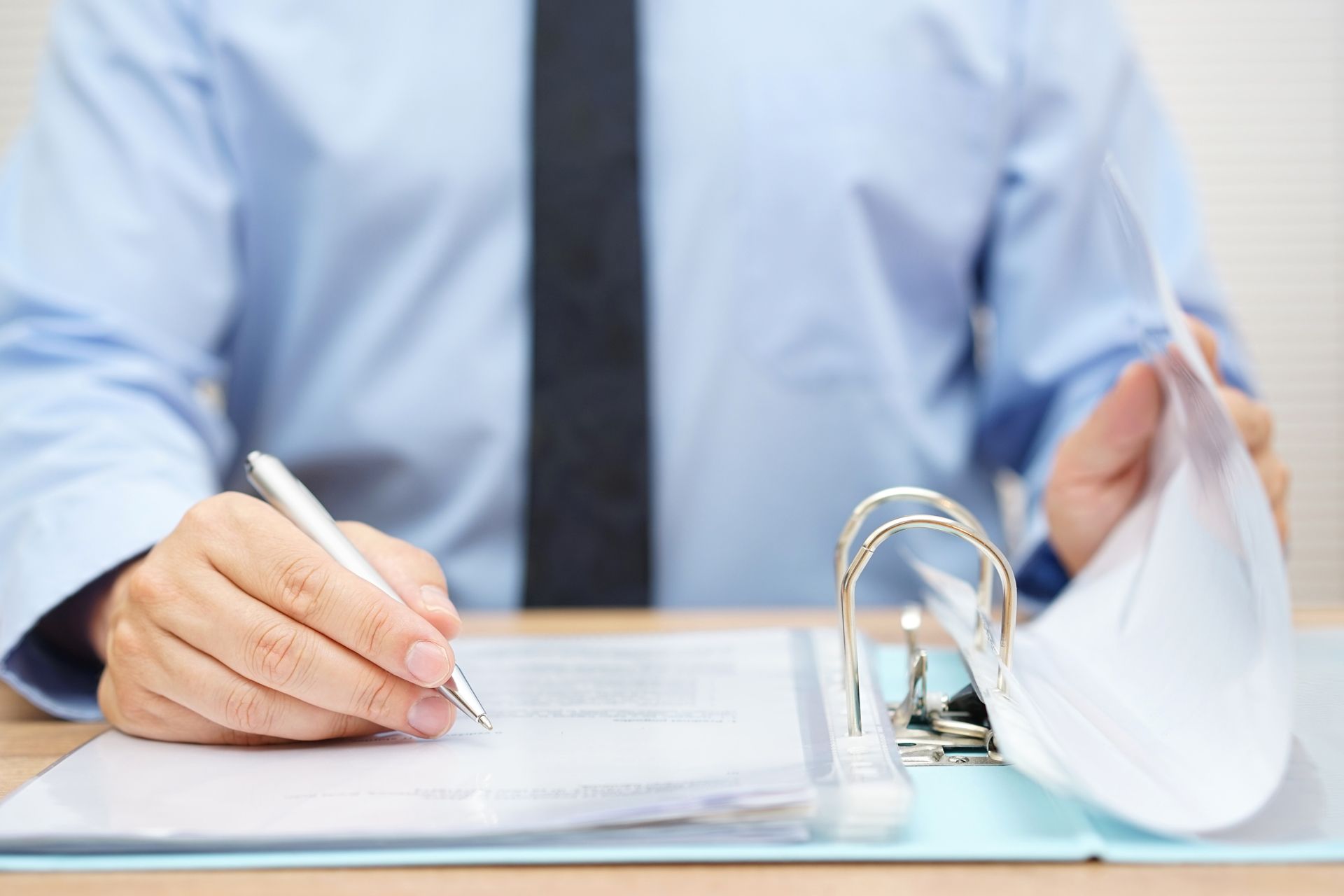 A man is sitting at a desk writing on a piece of paper