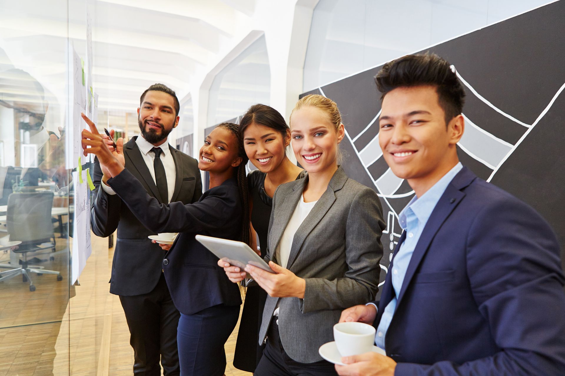 A group of business people are standing next to each other in an office