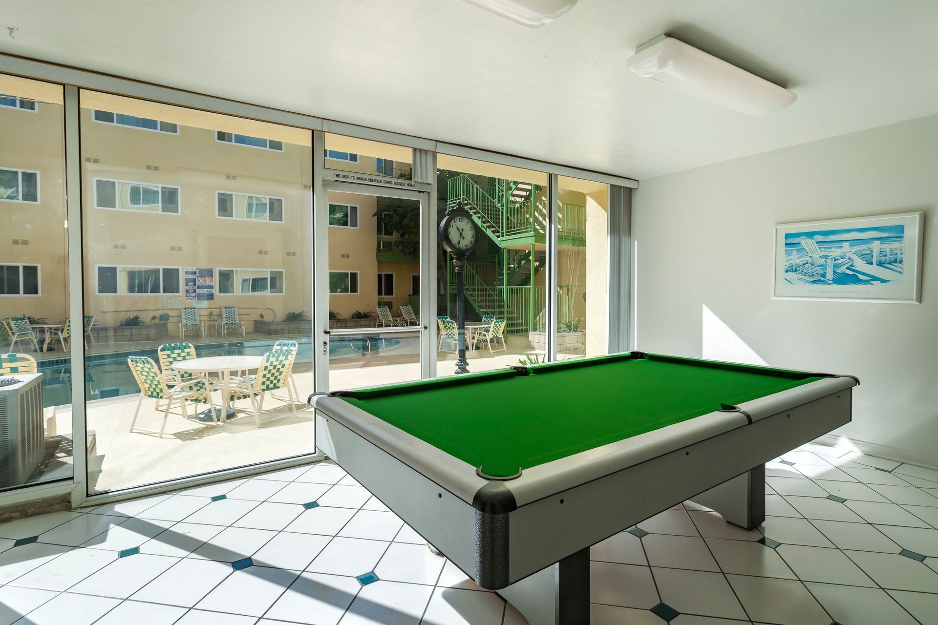 A pool table in a room with a lot of windows