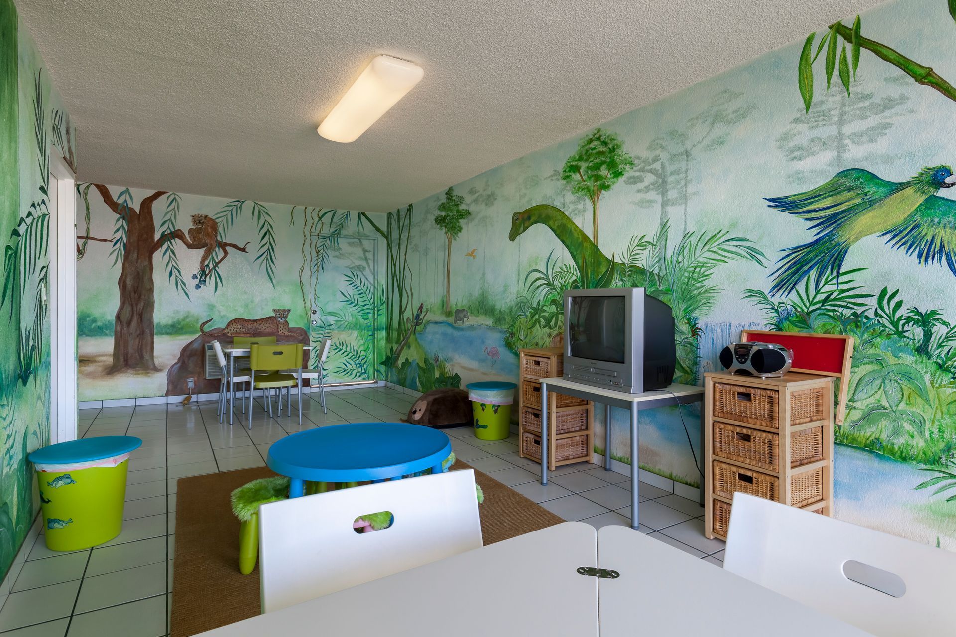 A children 's room with tables and chairs and a television