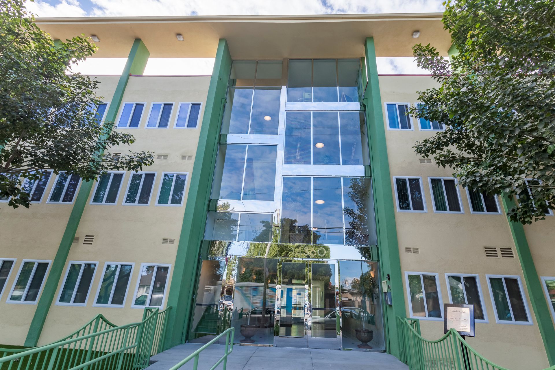 A large building with a lot of windows and trees in front of it