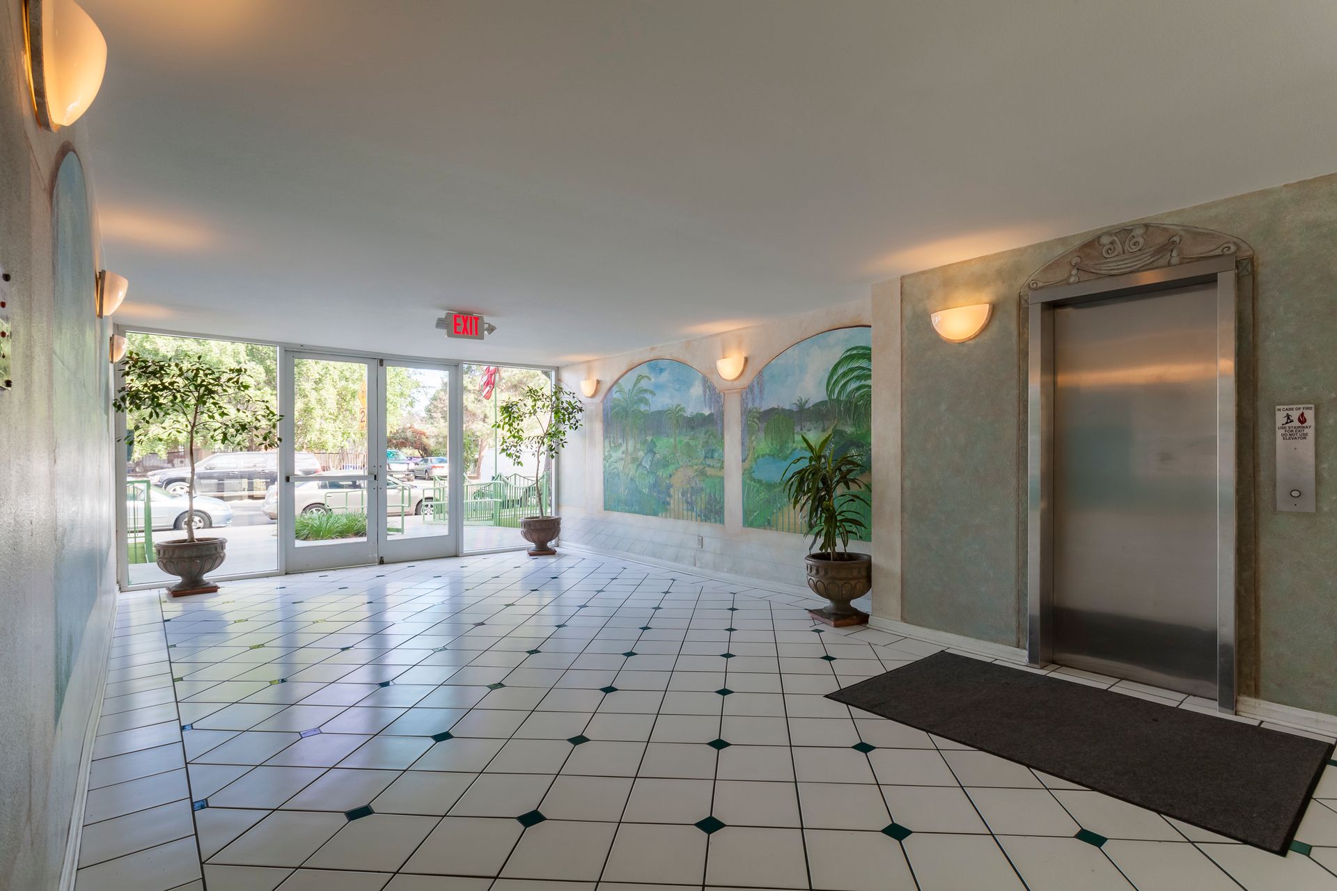 A large hallway with a stainless steel elevator