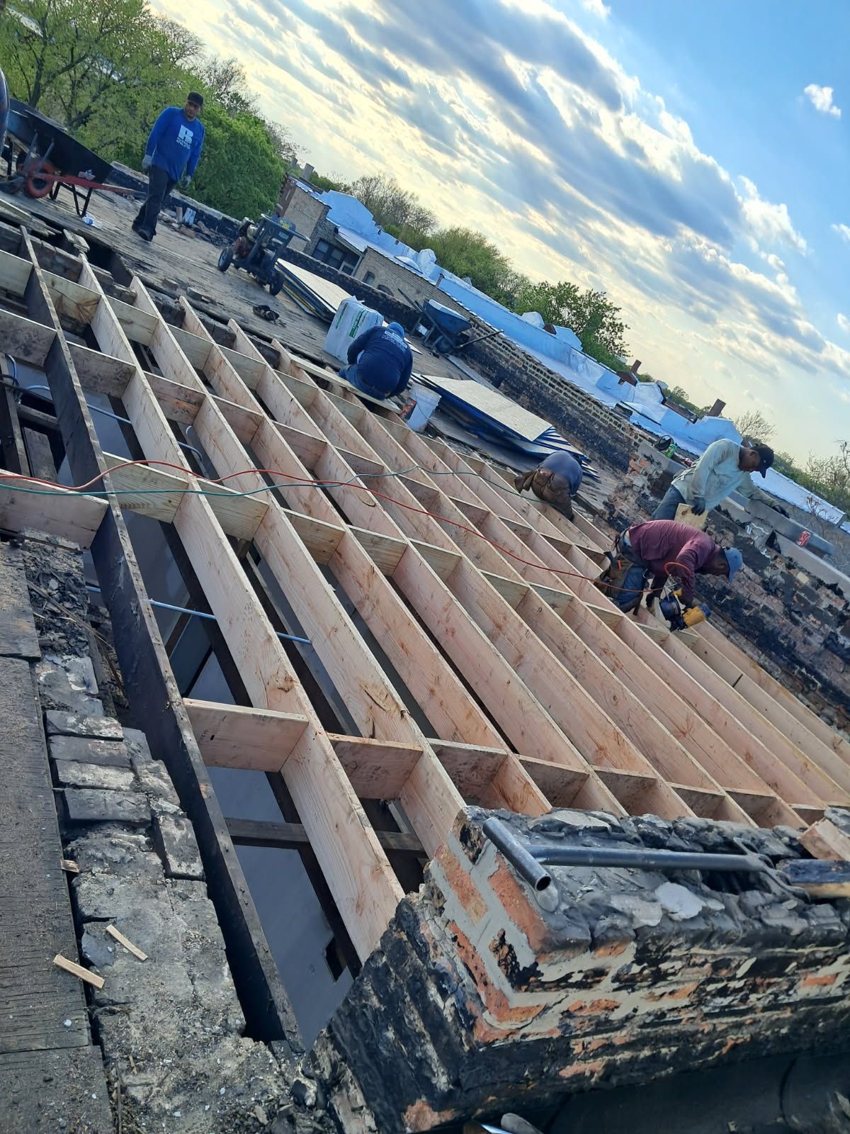 A group of people are working on the roof of a building.
