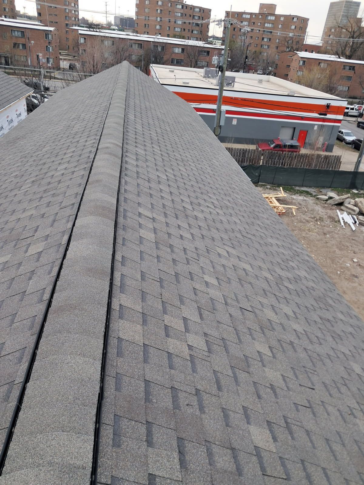 The roof of a building with a convenience store in the background.
