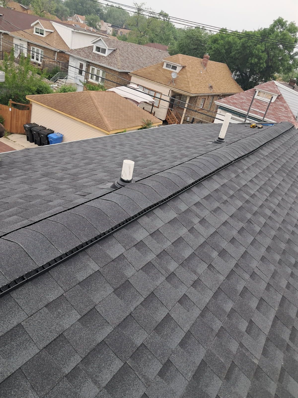 An aerial view of a roof with a lot of houses in the background.
