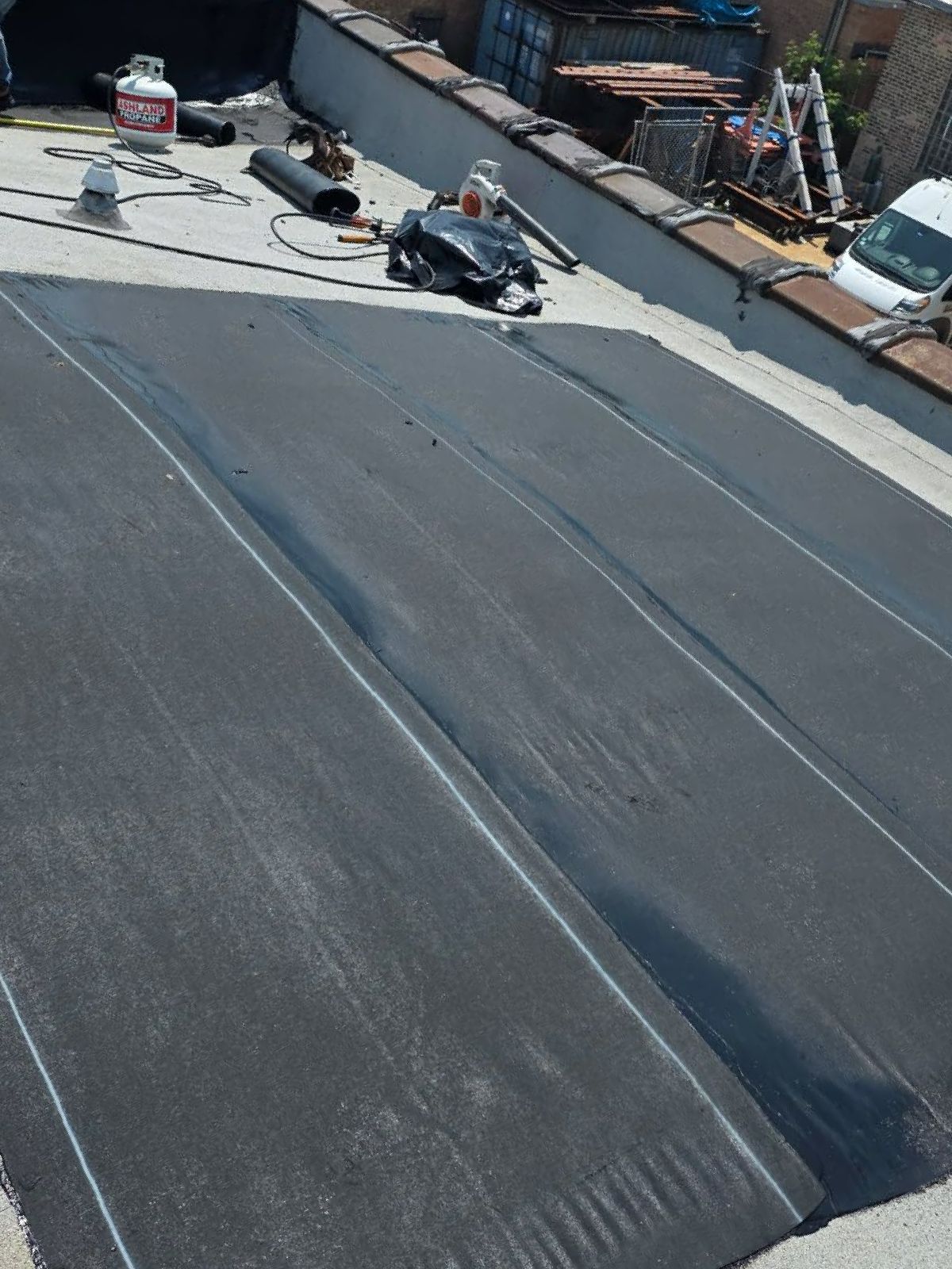 A black roof is being installed on top of a building.