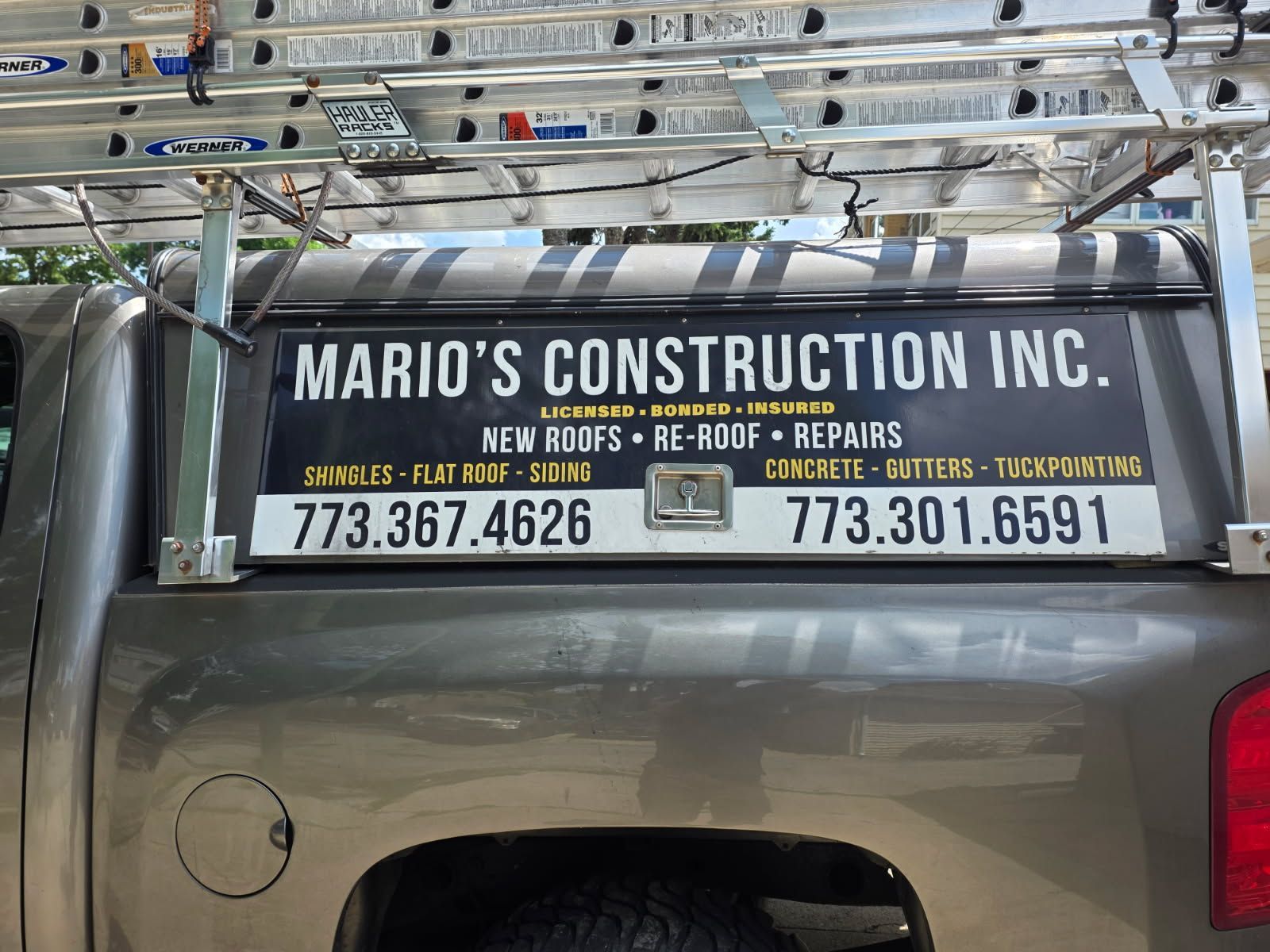 A truck with a sign on the back that says mario 's construction inc.