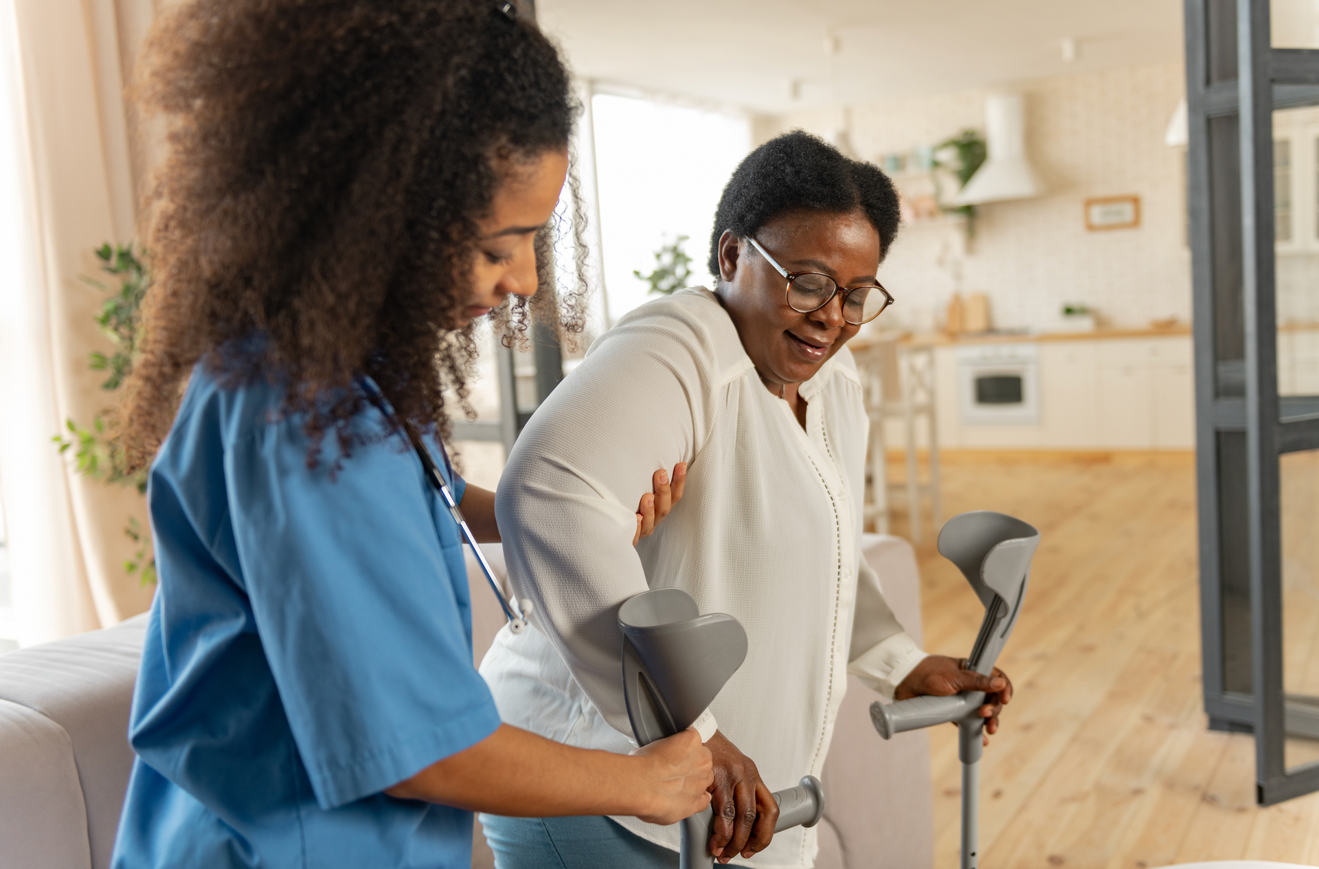 A nurse is putting a slipper on an elderly man 's foot.