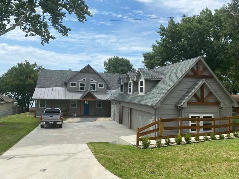 A truck is parked in front of a large house.