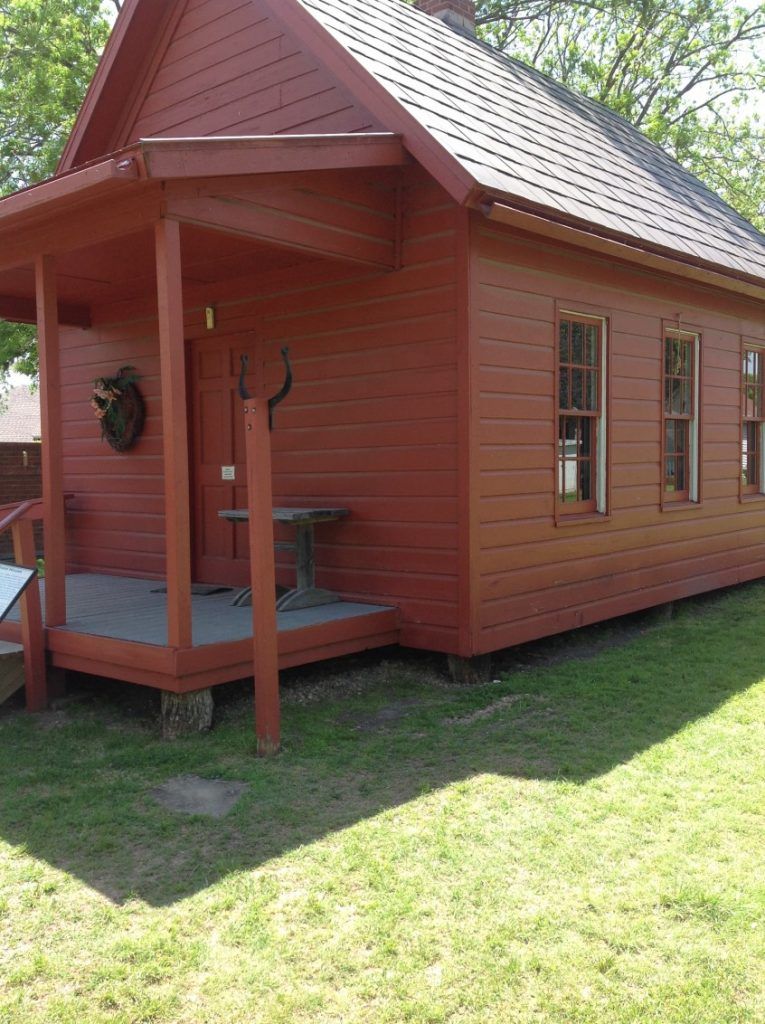 A small red house with a porch and stairs