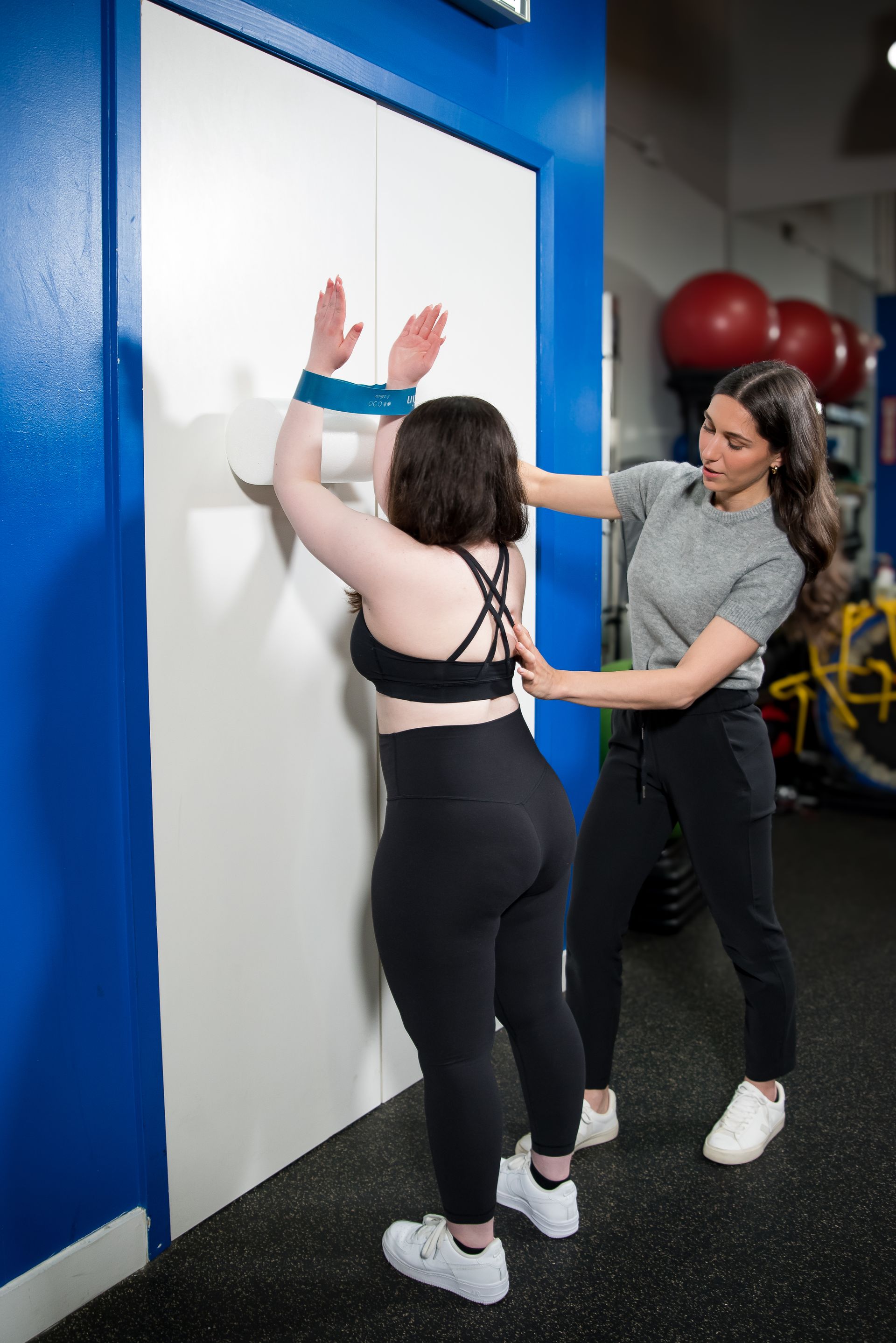 a man helps a woman do a plank on a mat