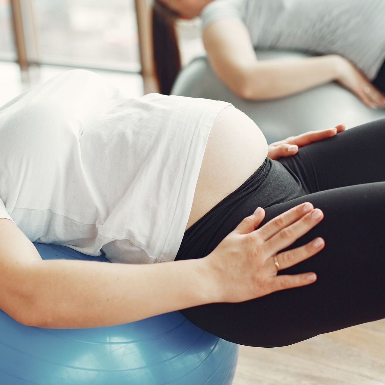 pregnant woman training on a medicine ball