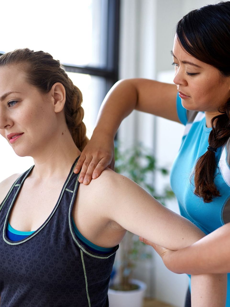 A woman is giving another woman a massage on her shoulder