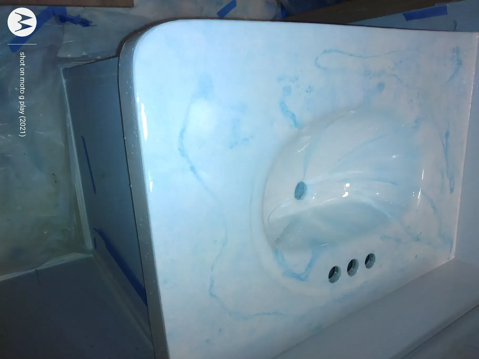 White bathroom sink with blue swirl pattern.