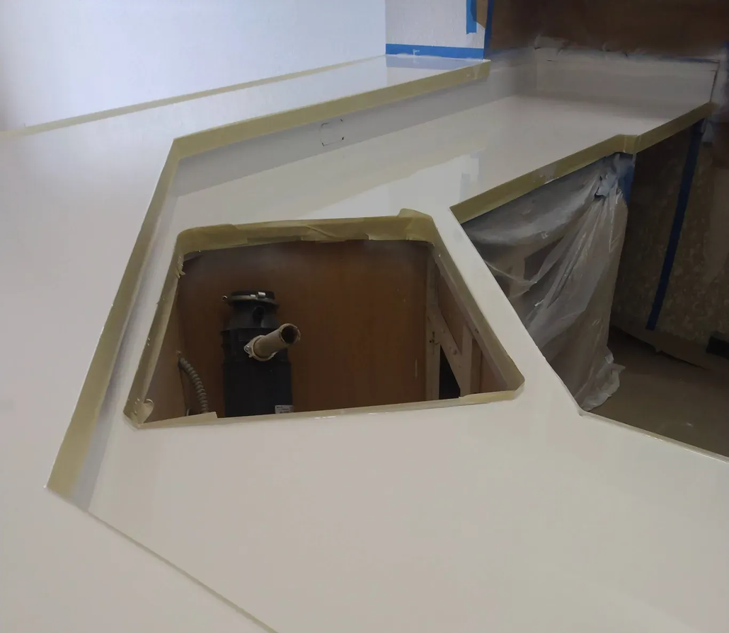 White kitchen countertop with an opening for a sink and garbage disposal.