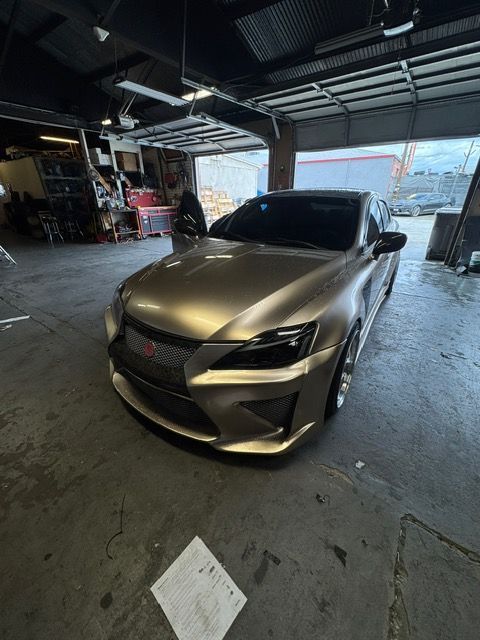 Silver sports car parked inside an auto shop near an open garage door.