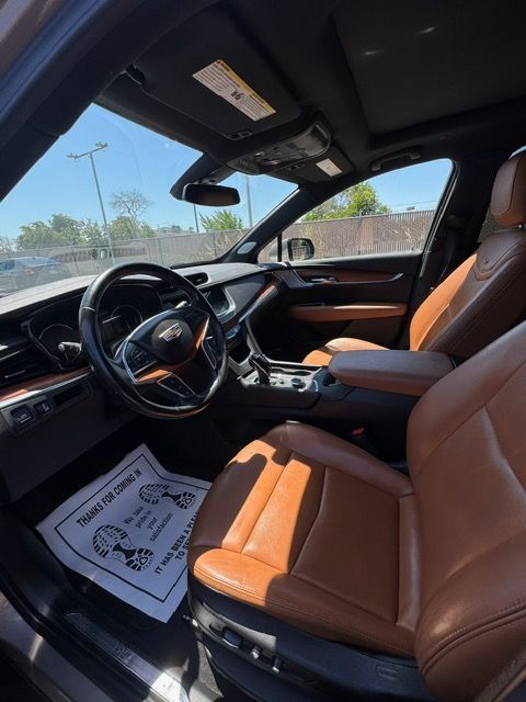 Luxury car interior with orange leather seats and black dashboard, viewed from the driver’s side.