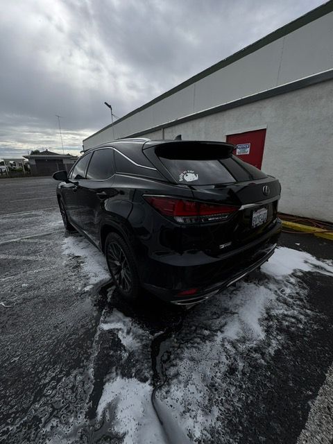 Black SUV parked on a wet, slushy lot beside a building under cloudy skies