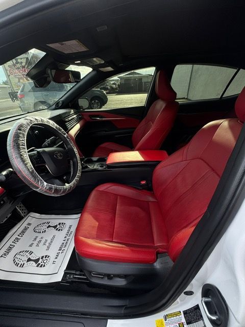 Red sports car interior with red seats, steering wheel cover, and open driver’s door