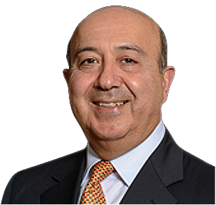 Vali Nasr in a suit and tie is smiling for the camera.