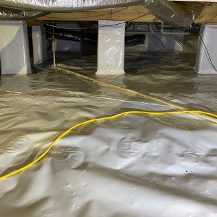 Crawl space with white vapor barrier on the floor and walls. A/C unit is visible in the corner.