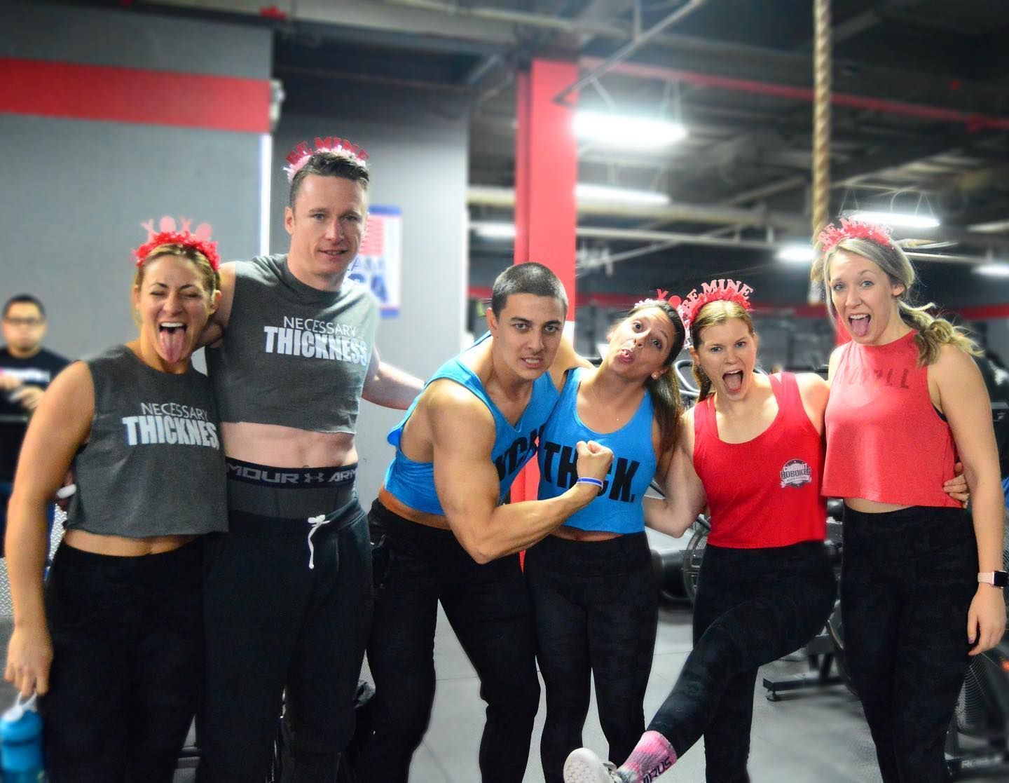 A group of people are posing for a picture in a gym.