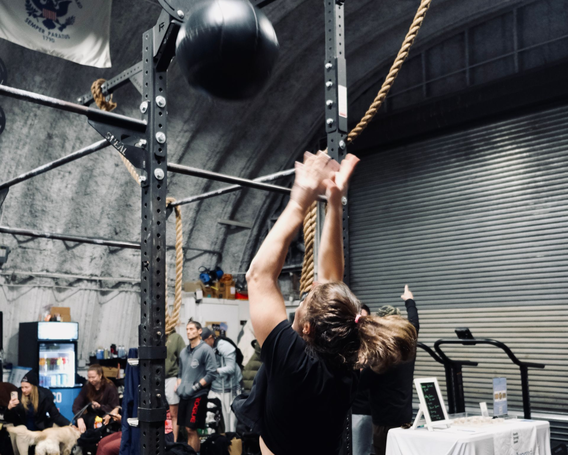A large empty gym with american flags hanging from the ceiling.