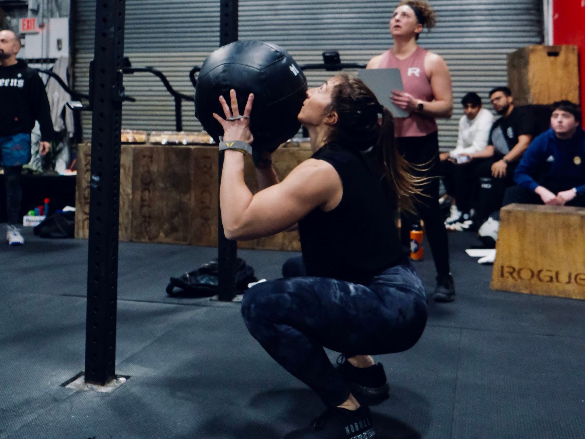 A large empty gym with american flags hanging from the ceiling.