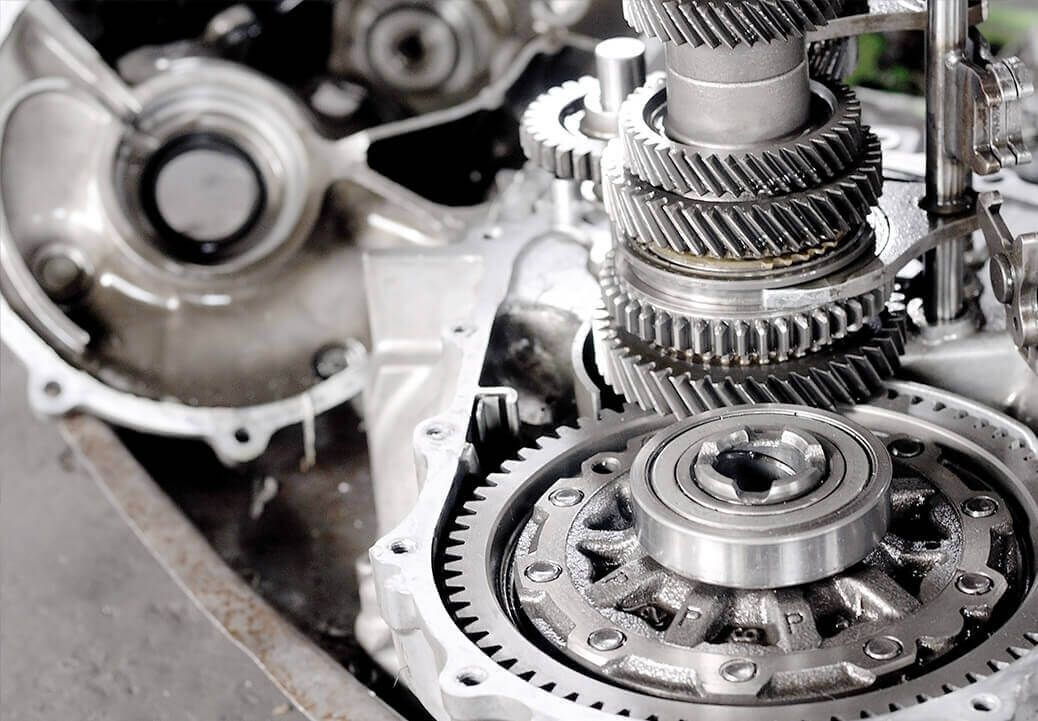 Close-up of car transmission gears and internal components in a metal casing.
