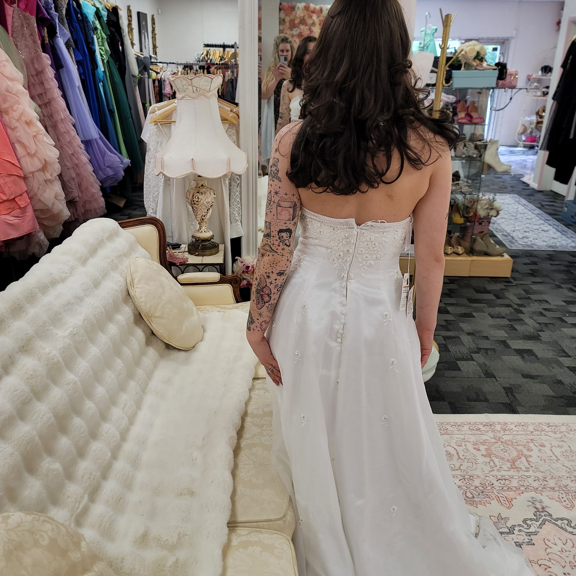 A woman in a white wedding dress is standing in a room