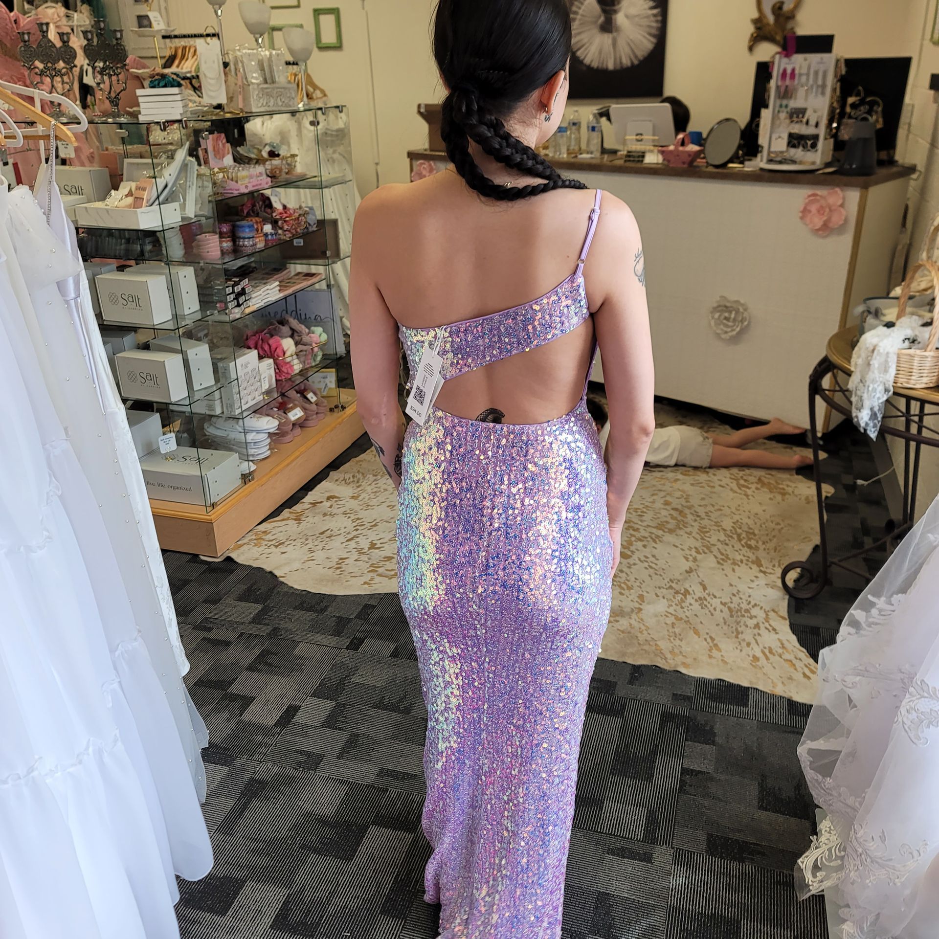 A woman in a purple sequined dress is standing in a store