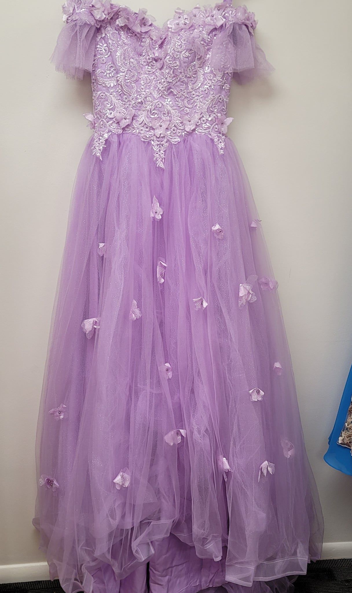 A purple dress with flowers on it is on a mannequin.