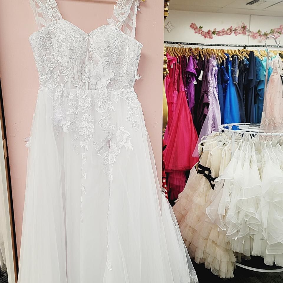 A white dress is hanging on a wall in a store.