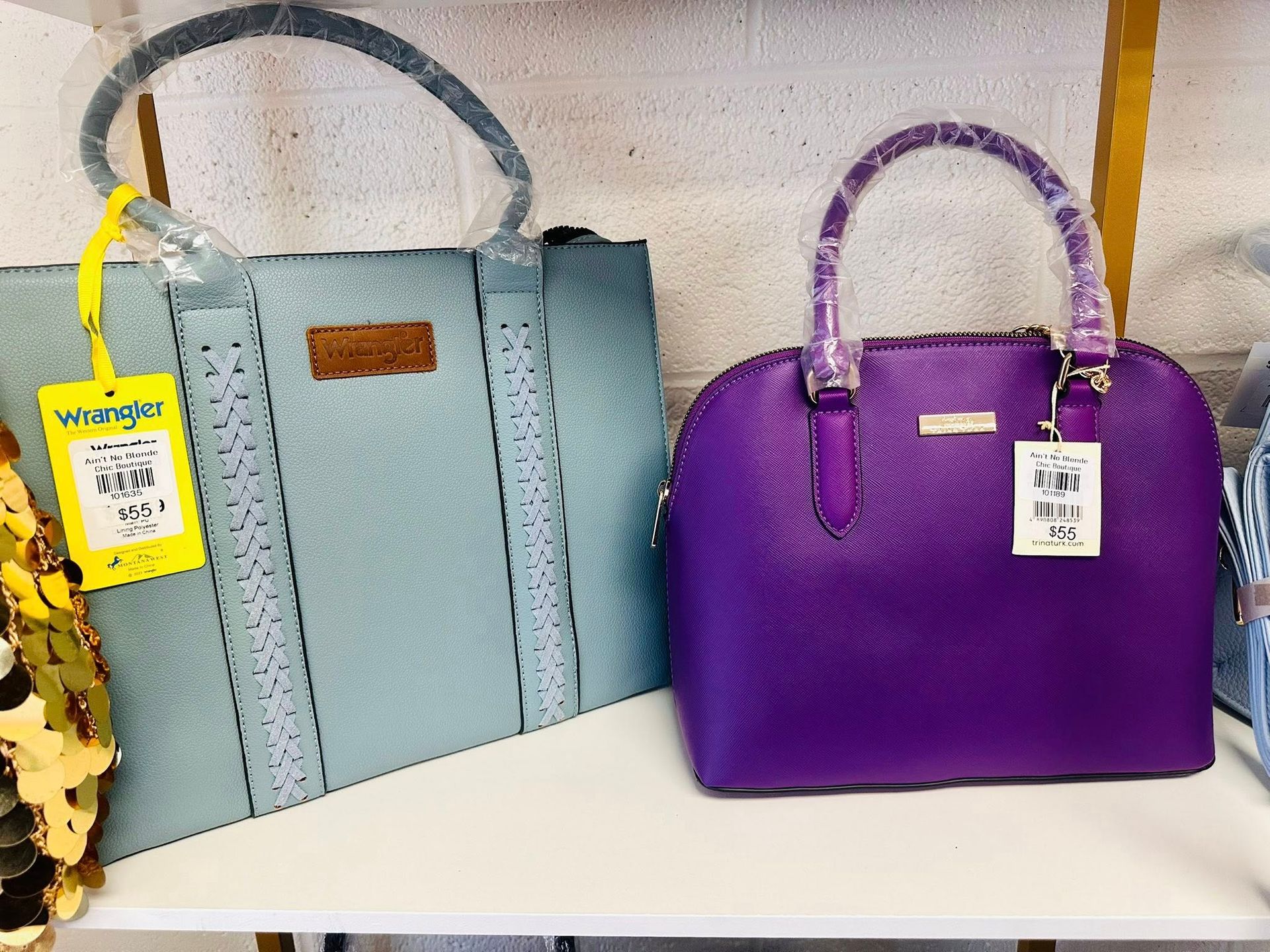 A purple purse and a blue purse are on a shelf