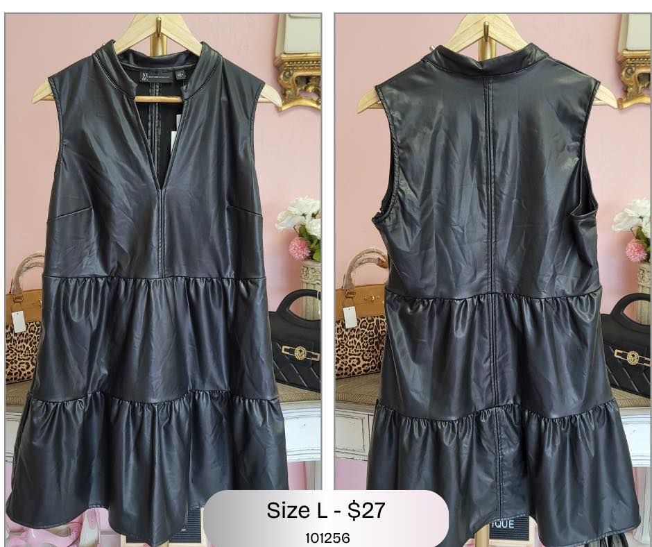 A black leather dress is hanging on a hanger.