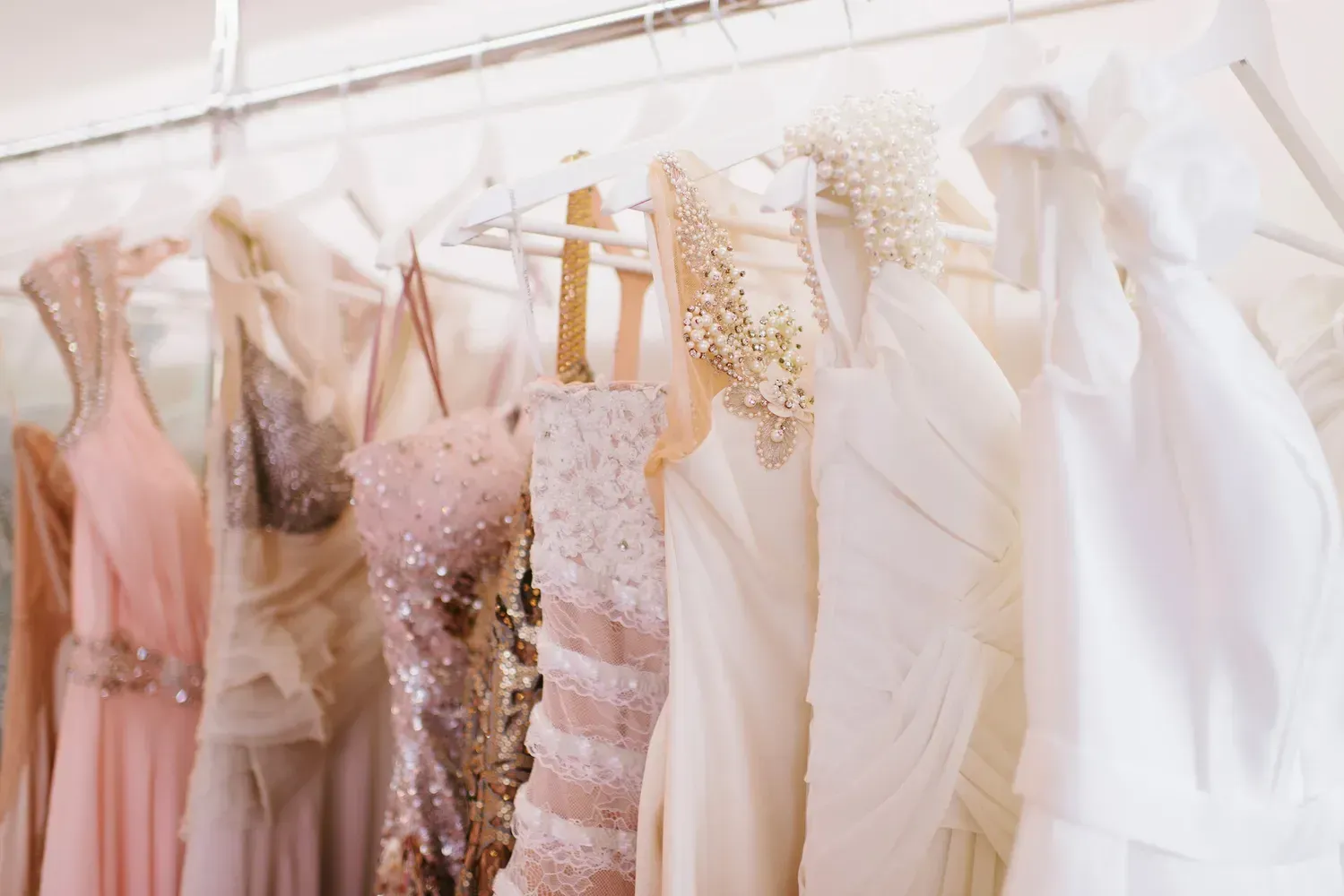 A row of wedding dresses hanging on a rack.