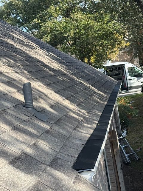 A roof with a gutter on it and a truck parked on the side of it.
