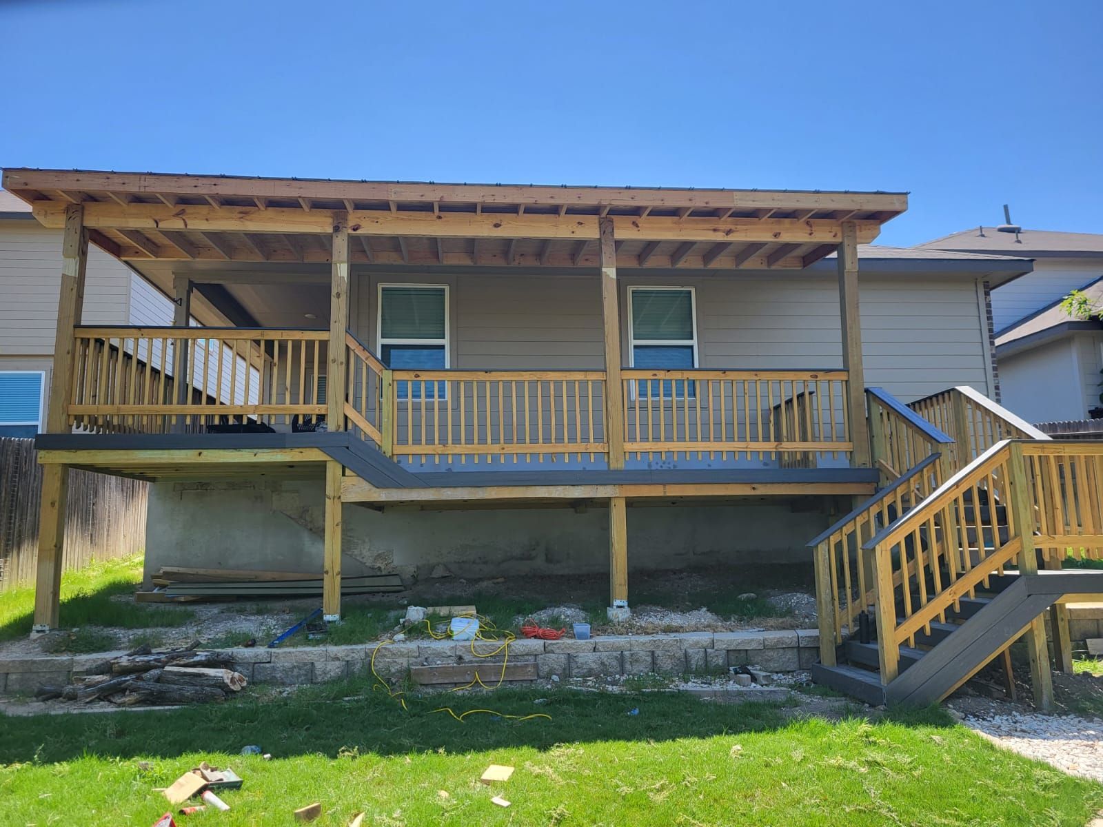 The back of a house with a wooden deck and stairs.
