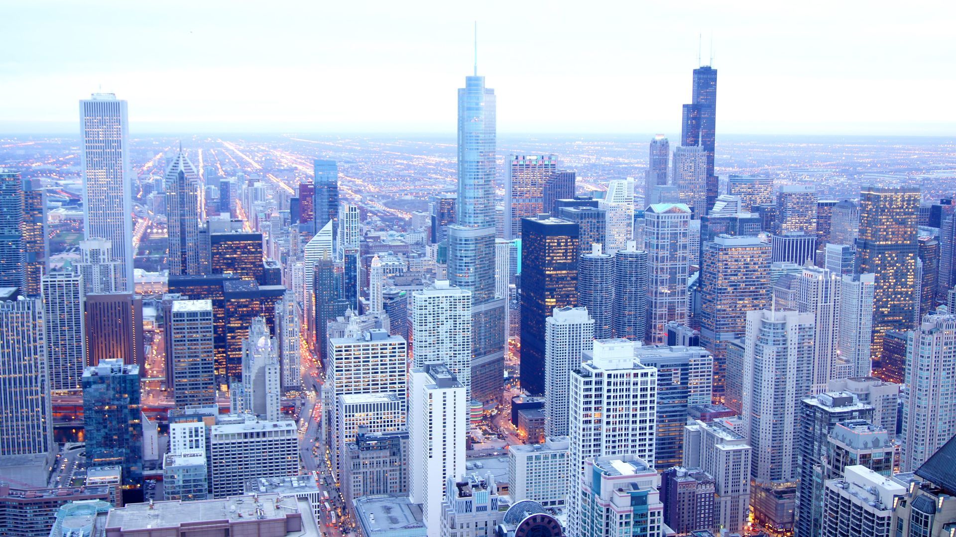 Snowy city skyline with tall modern skyscrapers under a pale winter sky