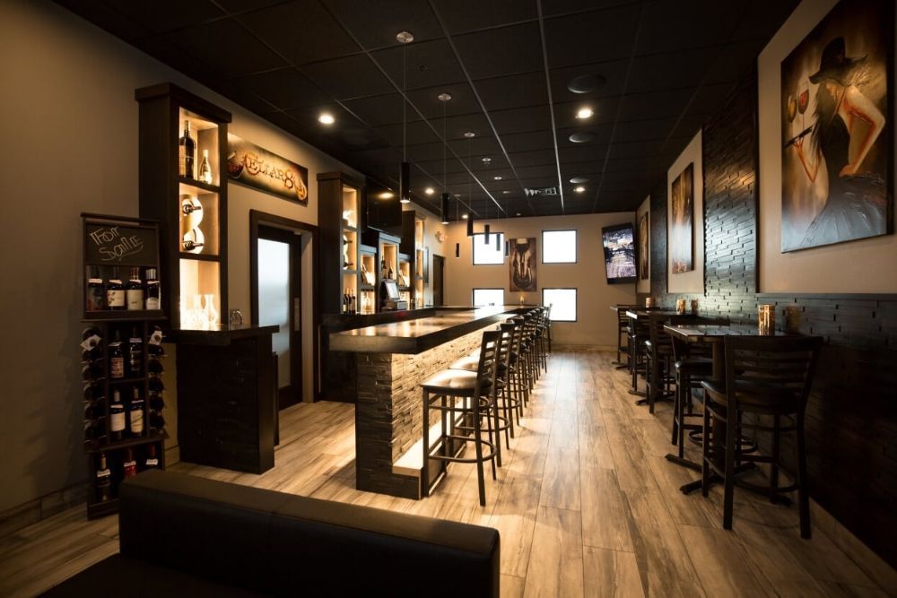 A restaurant with a long bar and tables and chairs