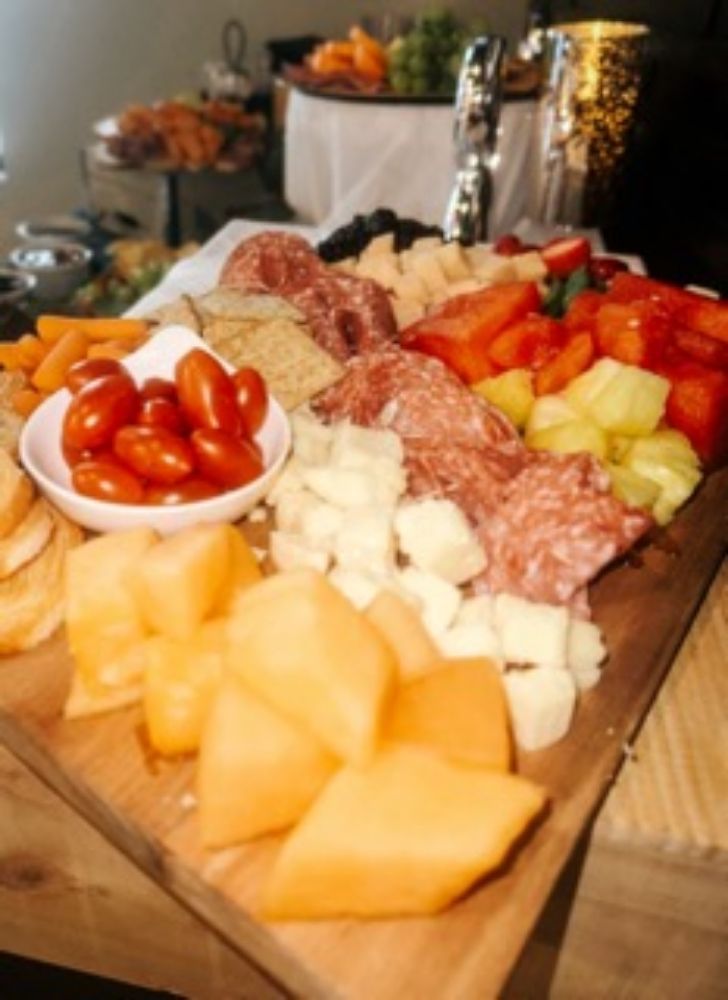 A wooden cutting board filled with meats and vegetables