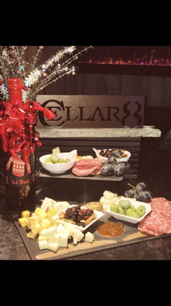 A table topped with plates of food and a bottle of wine.
