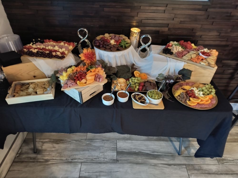 A table with a lot of food on it and a black table cloth.