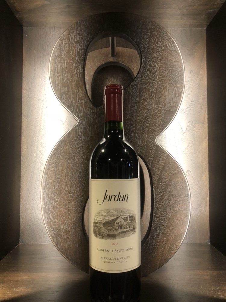 A bottle of wine is sitting in front of a number 8.