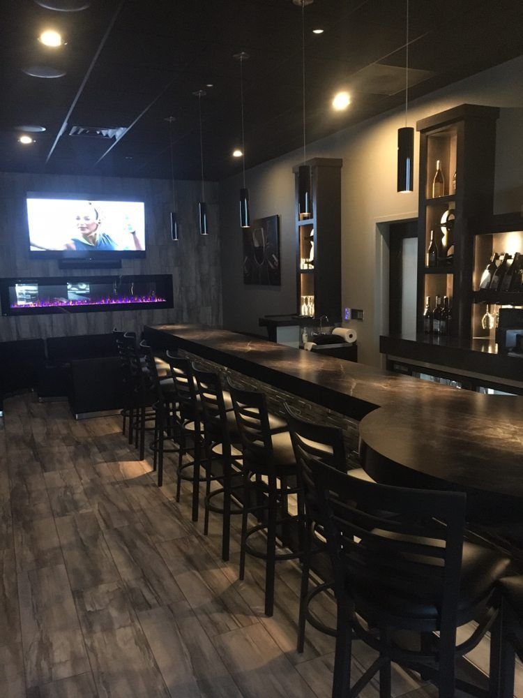 A restaurant with a long bar and chairs