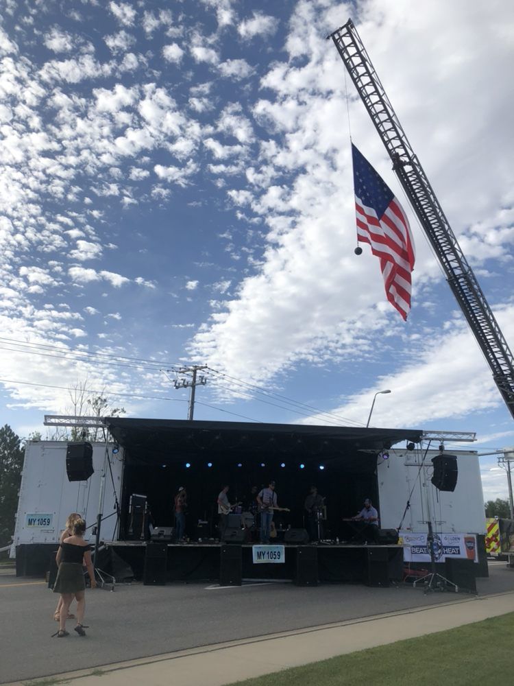 A large american flag is flying in front of a stage