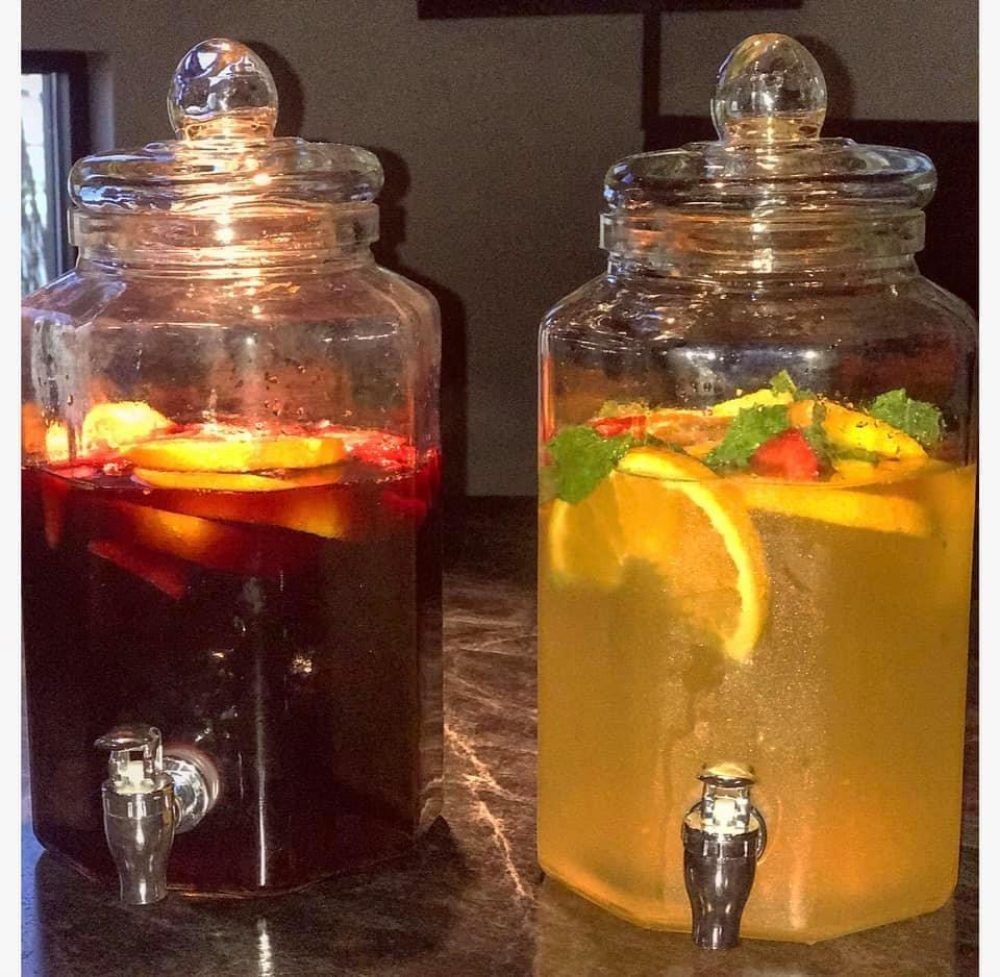 Two jars filled with different types of drinks on a table