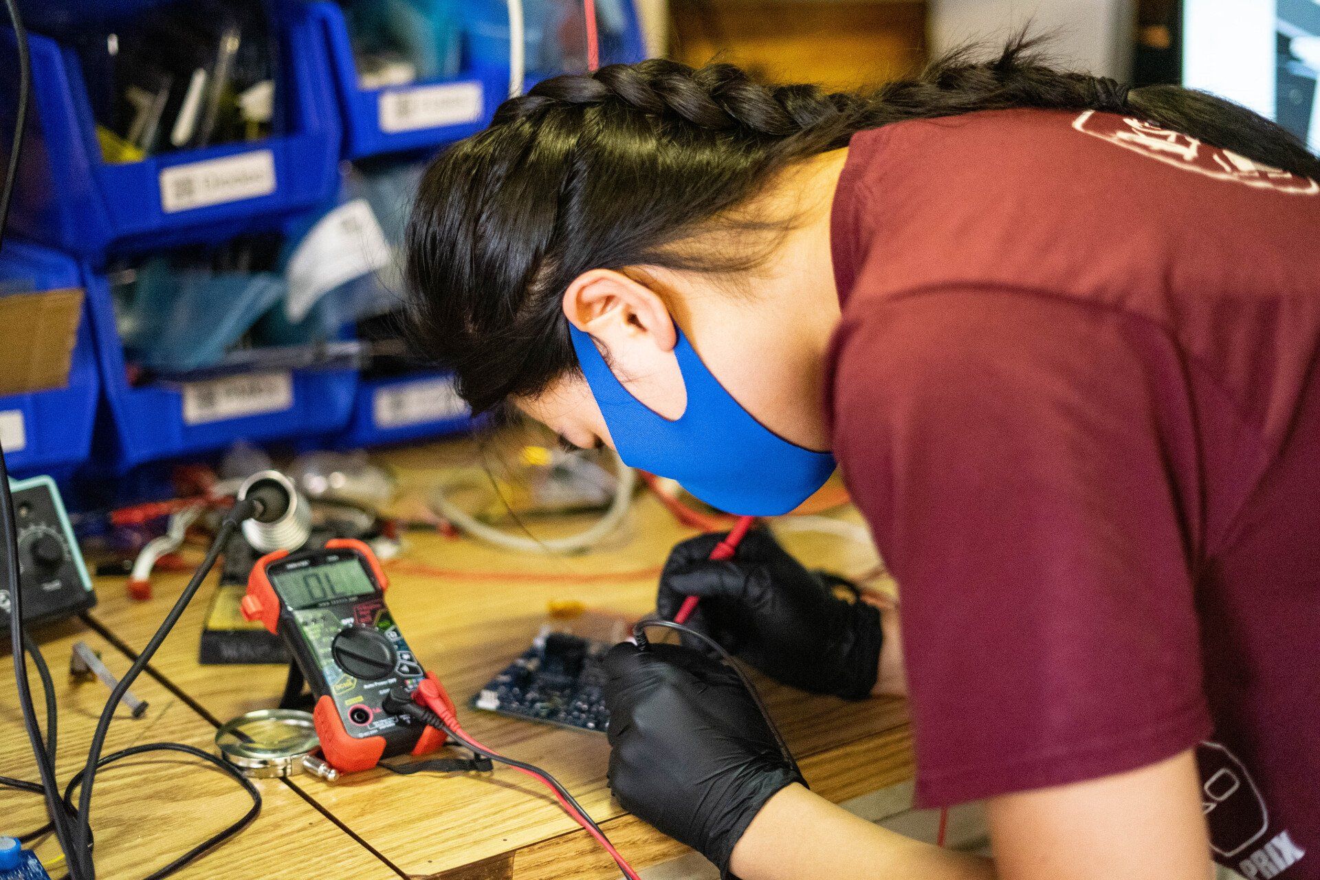 Lucy Zhang inspects a PCB.